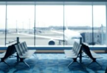 Near-Suction Claim Stuns Flyers Blurred view of an airport terminal with seats and an airplane in the background