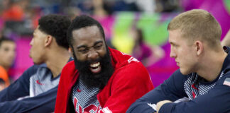 Basketball players on the bench sharing a laugh