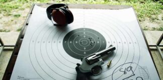 Revolver and ear protection on paper shooting target