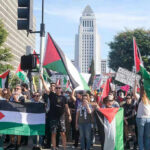 Protest Or Hate? Judge Drops Hammer Protesters holding signs and flags in a public square.