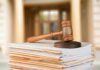 judge's gavel resting on a stack of case files