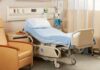 Hospital bed with blue linens in a patient room