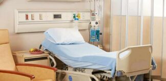 Hospital bed with blue linens in a patient room
