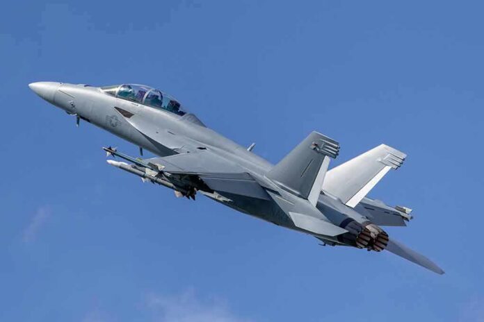 Twin-engine fighter jet climbing in a clear blue sky