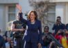 Why Critics Are Focused on Point Dume woman in navy suit waving at an outdoor event