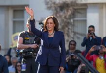 woman in navy suit waving at an outdoor event