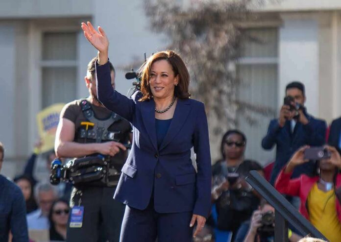 shutterstock_1296858949 woman in navy suit waving at an outdoor event