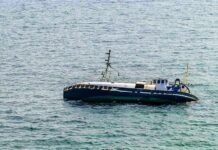 An abandoned boat floating on the ocean surface
