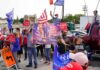 Crowd of people at a political rally holding flags and signs