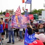 Crowd of people at a political rally holding flags and signs