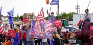 Crowd of people at a political rally holding flags and signs