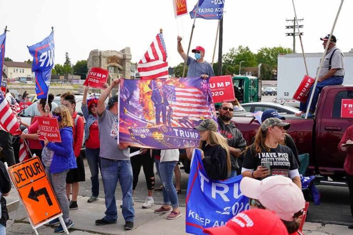 shutterstock_1819248140 Crowd of people at a political rally holding flags and signs