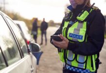 Bush-Costumed Cop Bags 74 — Legal? Police officer using a smartphone during a roadside stop
