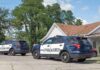 Police Knew Him — He Got In Anyway Two police SUVs parked near a suburban house