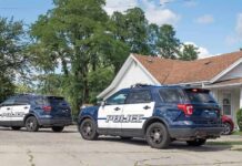 Two police SUVs parked near a suburban house