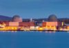 nuclear power plant with two domed reactor buildings by water at dusk