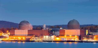 nuclear power plant with two domed reactor buildings by water at dusk
