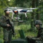 quadcopter drone hovering near soldiers in a forest