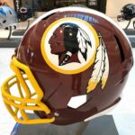 maroon football helmet with yellow facemask on display