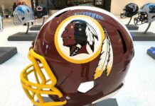 maroon football helmet with yellow facemask on display