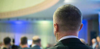 Man with earpiece at a crowded event.