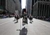 Kraig Urbik leads a Scottish parade in full regalia down a city street