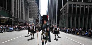 Kraig Urbik leads a Scottish parade in full regalia down a city street