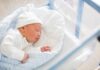 Newborn baby sleeping in hospital bassinet