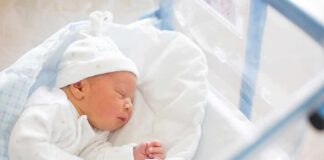 Newborn baby sleeping in hospital bassinet