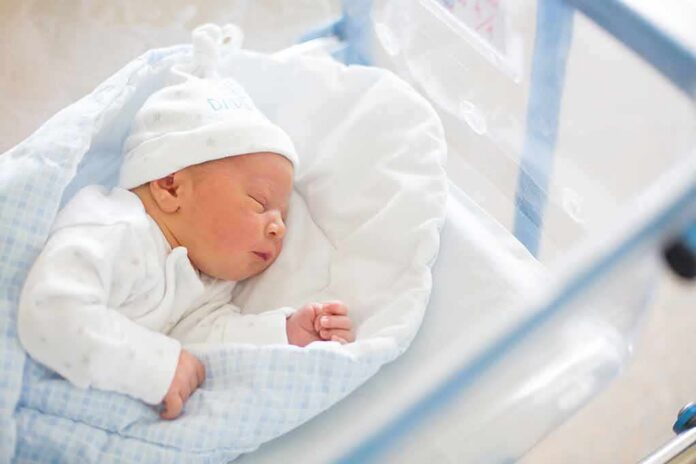 Newborn baby sleeping in hospital bassinet