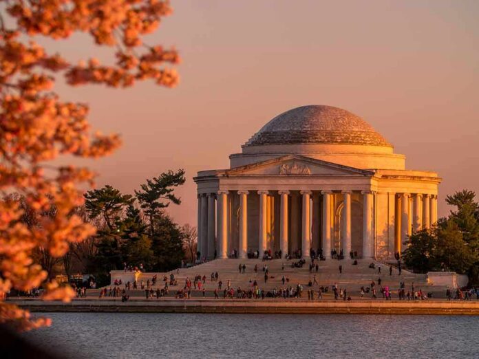 shutterstock_1064680298 Jefferson Memorial at sunset with cherry blossoms and visitors by the water