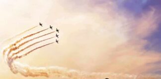 formation jets performing aerobatics above crowd