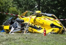 yellow helicopter crash scene on grassy field