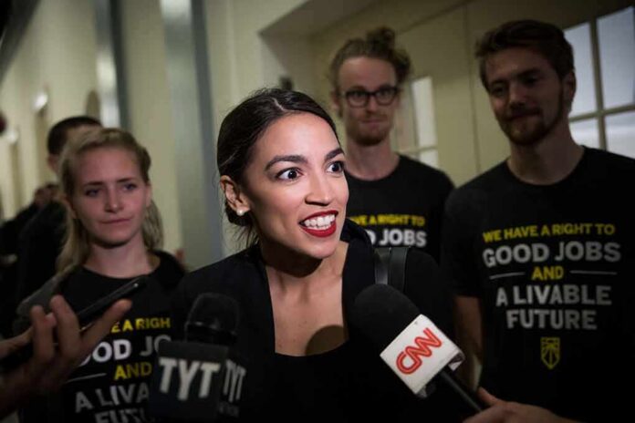 shutterstock_1231811017 Woman speaking to reporters with microphones surrounded by supporters