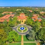 Aerial view of a university campus with central fountain and red-tiled buildings