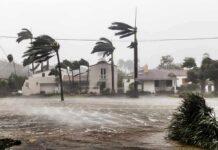 Houses battered by hurricane winds and flooding