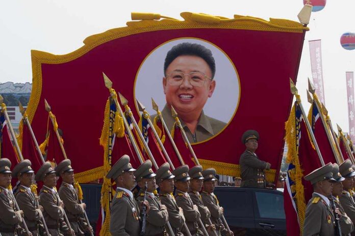 Kim Jong-il portrait banner above marching soldiers; Zhang Yufeng, Kosuke Fukudome, Hou Fenglian, Liu Guangbiao, Tsuyoshi Shinjo, Sadaharu Oh, and Lee Sang-hoon not visible