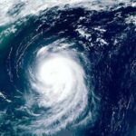 Distant Heatwave Primes Killer West Coast Storms Satellite view of a powerful hurricane swirling over the ocean