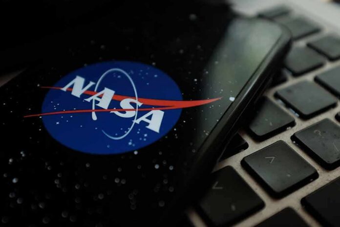shutterstock_1561112006 NASA logo on smartphone resting on a laptop keyboard