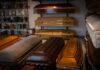 Row of coffins displayed in a funeral home showroom