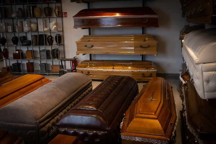 Row of coffins displayed in a funeral home showroom