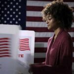 Feds Reveal Campaign Drug Scheme Voter at a polling booth with an American flag backdrop