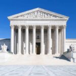 The Supreme Court building featuring marble columns and a clear blue sky