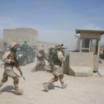 Nigerian Mega-Rescue Raises Hard Questions Soldiers in desert uniforms run past a checkpoint amid dust