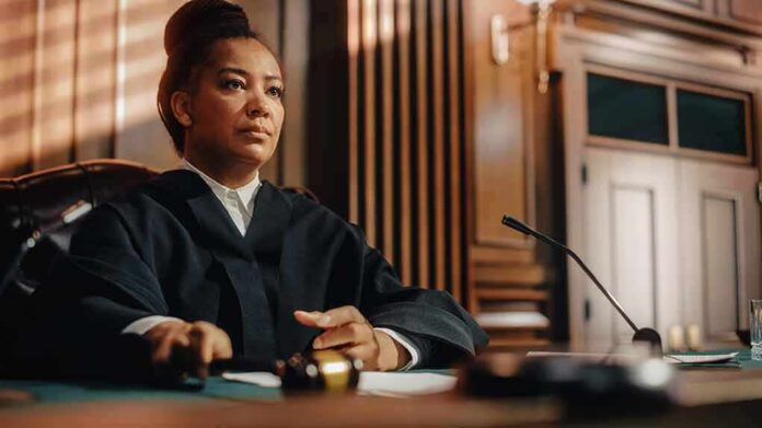 Judge seated at bench holding a gavel