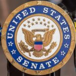 Socialist Leader Doubles Down on Abolition Agenda United States Senate seal at a podium