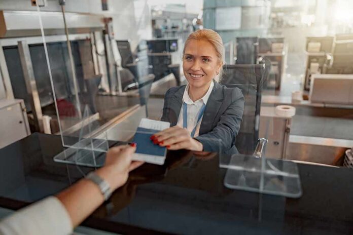 shutterstock_2186094269 airport check-in agent handing back a passport