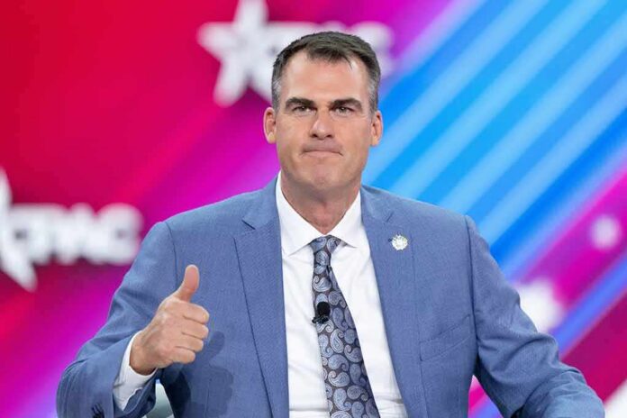 man in blue suit giving thumbs up on stage