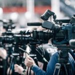 Restaurant Owner’s Birthday Clash Goes Viral Broadcast cameras on tripods at a press event