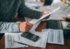 Microgrid Roadblock Trips Oracle Megaproject Person reviewing bills with calculator at cluttered desk